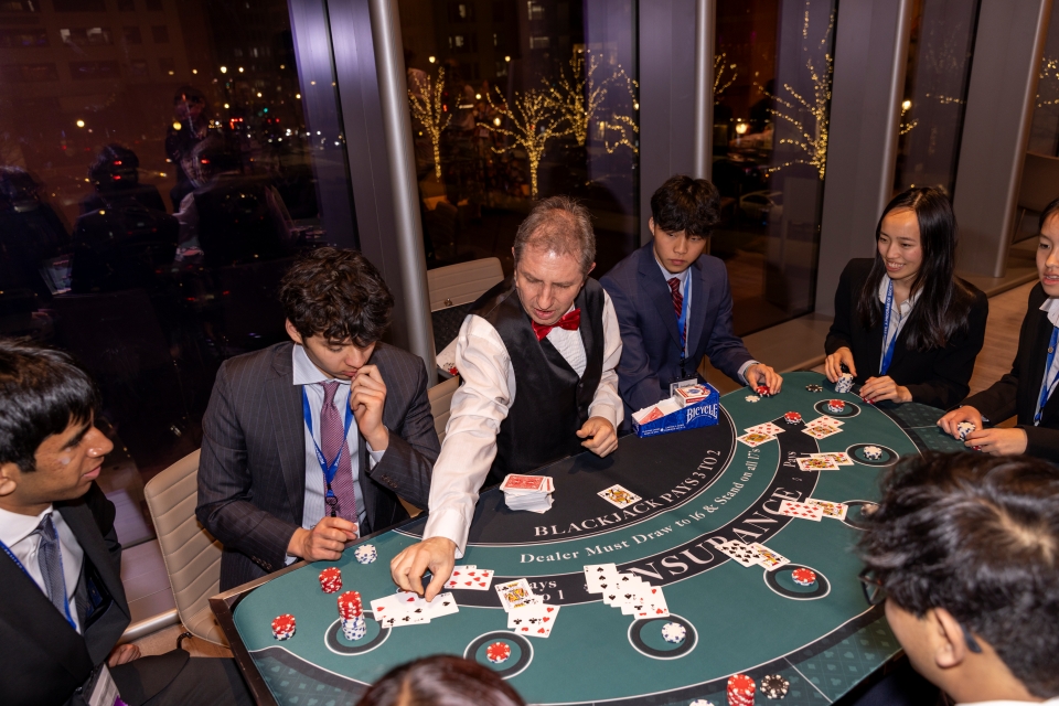 A dealer deals cards as STS finalists play in the blackjack tournament