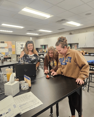 North Dakota STEM Research Fellows in a lab inspecting equipment.