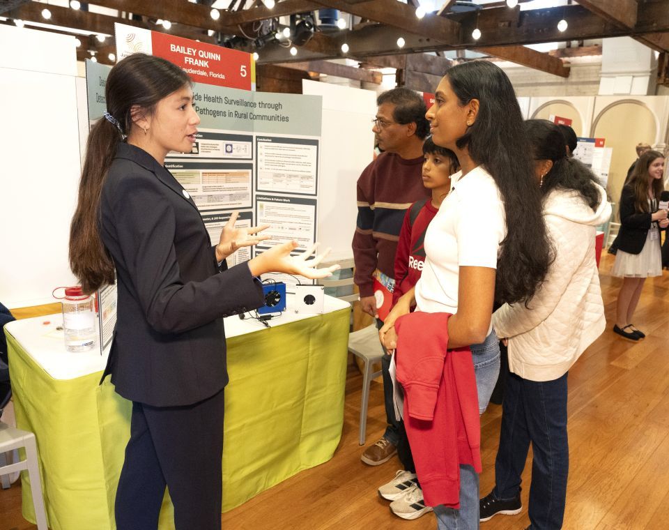 Finalist Bailey Frank shares her research with visitors at the 2026 Thermo Fisher JIC Public Exhibition of Projects.
